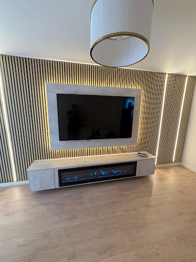 Modern concrete hearth and slatted backlit TV wall